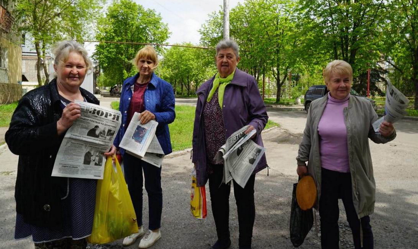 Люди тішаться, коли серед найнеобхіднішого, що їм періодично привозять і роздають волонтери, не тільки харчі чи медикаменти, а й місцева газета. Фото з сайту nsju.org